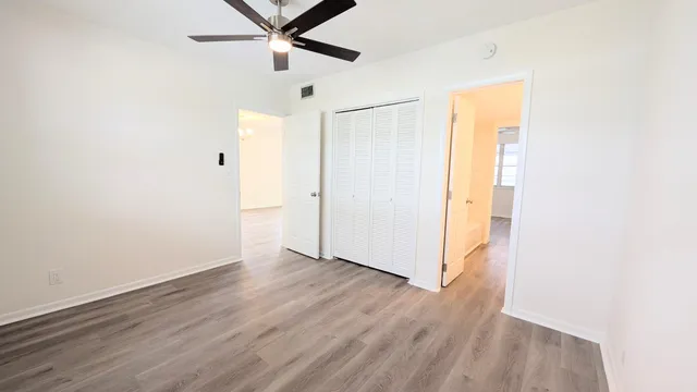 a view of a room with wooden floor and a ceiling fan