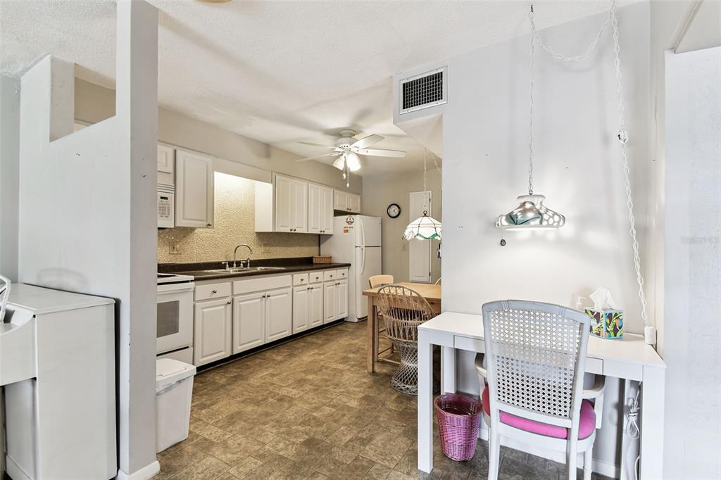 250 Rosery Road Northwest, Unit 333 Largo, FL 33770 - Photo 16 of 63 a kitchen with a refrigerator and white cabinets