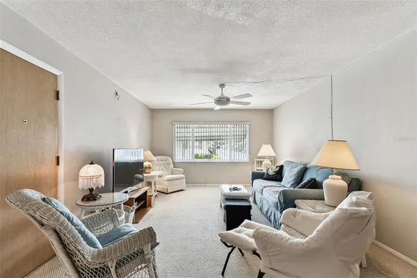 a kitchen with stainless steel appliances a white cabinets wooden floors and a chandelier