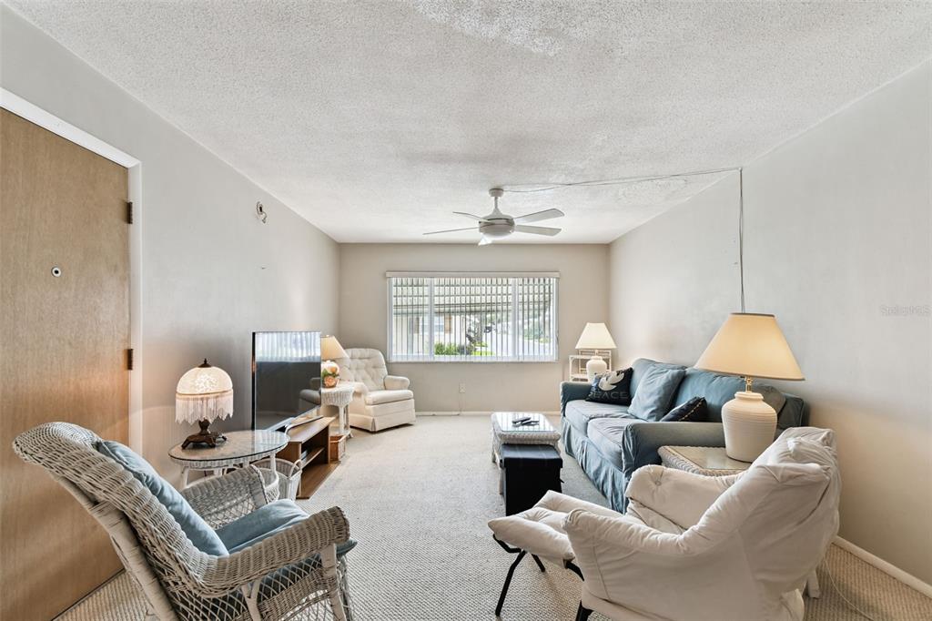 250 Rosery Road Northwest, Unit 333 Largo, FL 33770 - Photo 20 of 63 a living room with furniture a window and a chandelier
