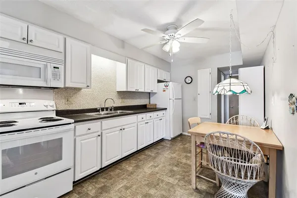 a kitchen with granite countertop a sink and a white cabinets