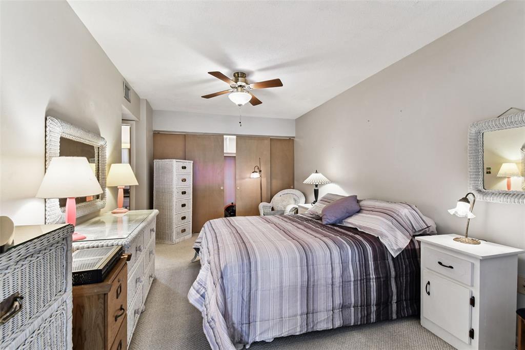 250 Rosery Road Northwest, Unit 333 Largo, FL 33770 - Photo 40 of 63 a spacious bedroom with a bed and a chandelier