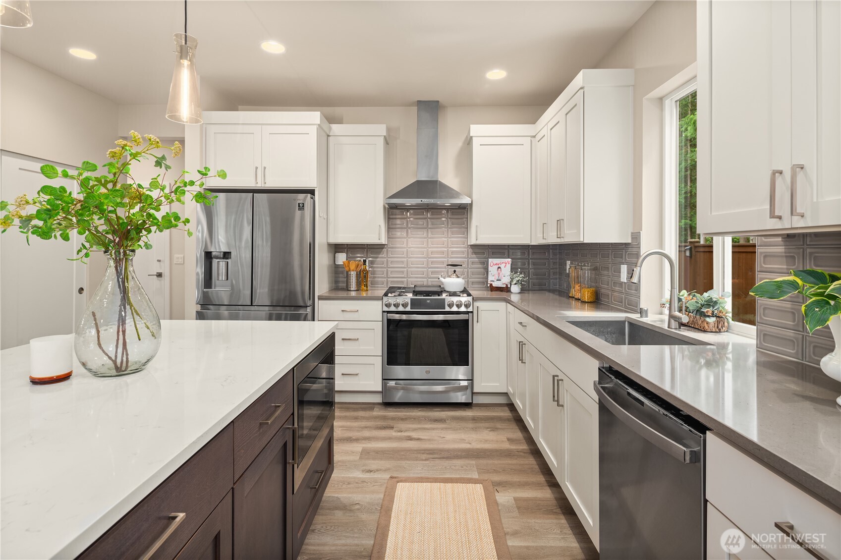 22308 17th Avenue West, Unit 12 Bothell, WA 98021 - Photo 8 of 33 a kitchen with stainless steel appliances kitchen island granite countertop a refrigerator a sink dishwasher and white cabinets with wooden floor