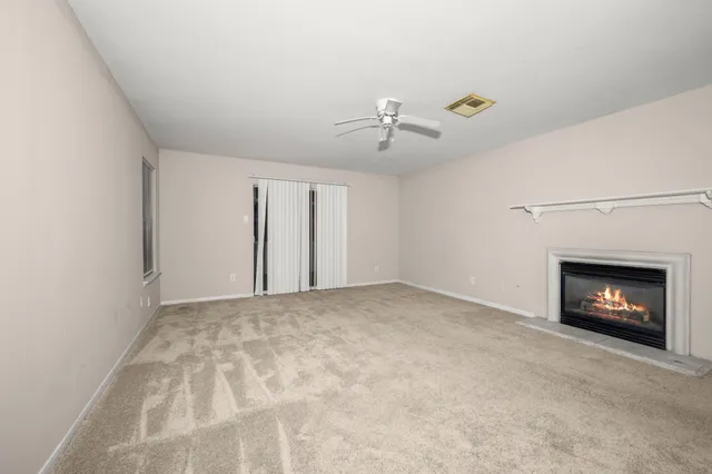 an empty room with windows and fireplace