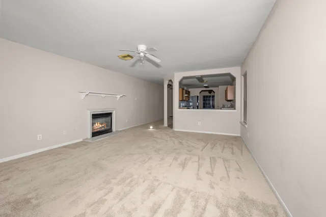 a view of an empty room with a fireplace and a window