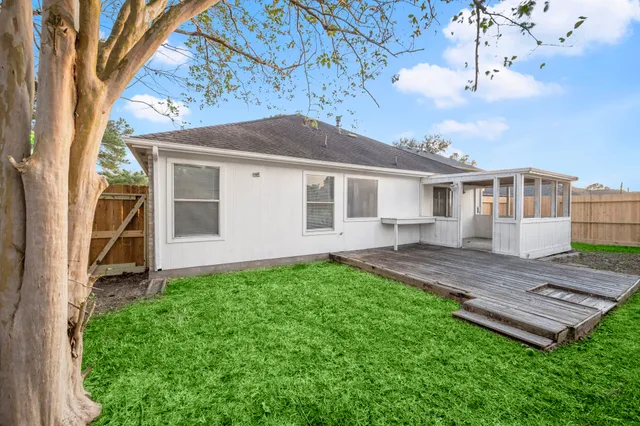 a view of a house with a yard and wooden fence