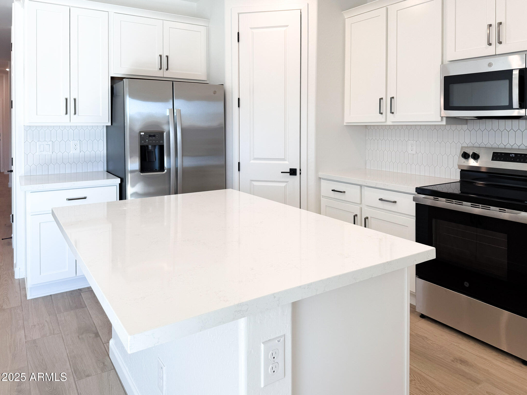 18203 La Senda Drive West Surprise, AZ 85387 - Photo 4 of 43 a kitchen with stainless steel appliances a refrigerator sink and white cabinets