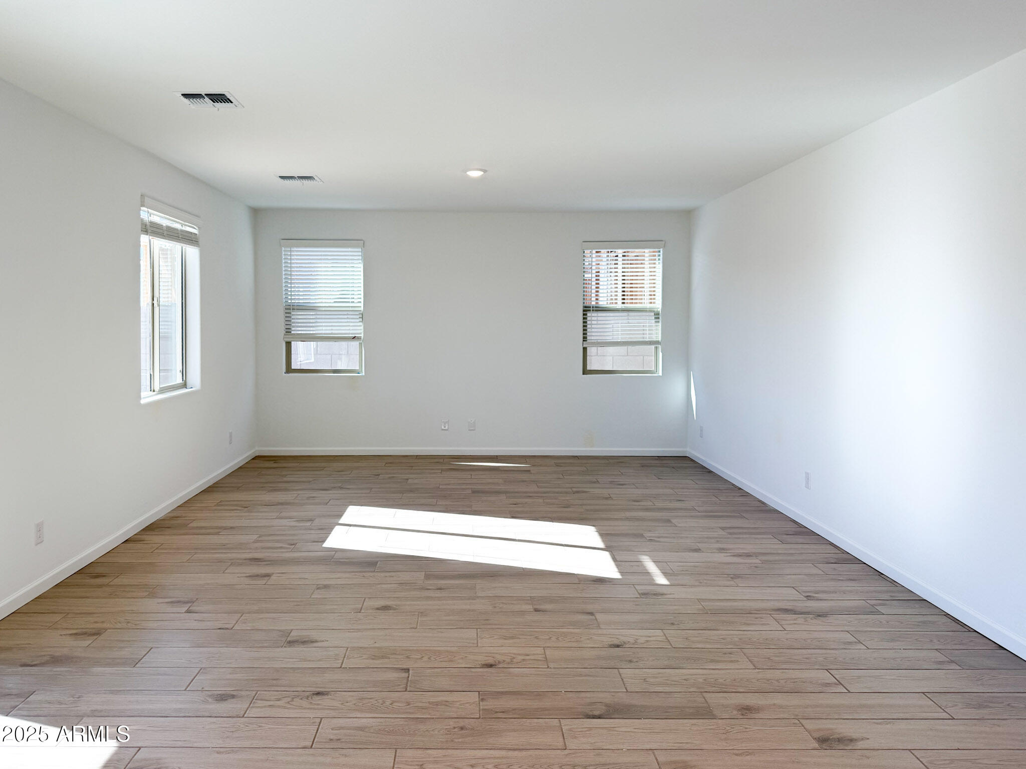 18203 La Senda Drive West Surprise, AZ 85387 - Photo 7 of 43 an empty room with wooden floor and windows