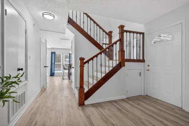 a view of a dining room with furniture a chandelier and wooden floor