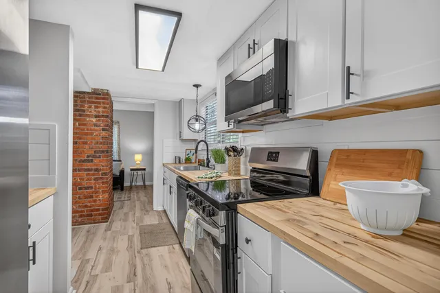 a kitchen with stainless steel appliances kitchen island a refrigerator sink and cabinets