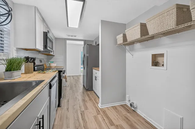a view of a hallway with bathroom and wooden floor