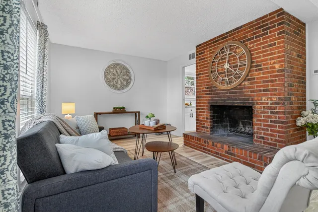 a living room with furniture a fireplace and a large window