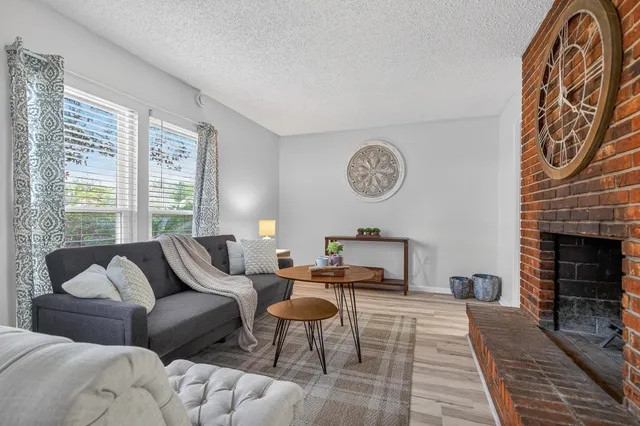 a living room with furniture a fireplace and a large window