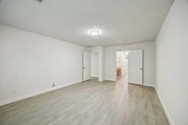 a view of an empty room with wooden floor
