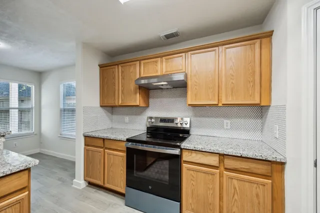 a kitchen with granite countertop white cabinets and white appliances