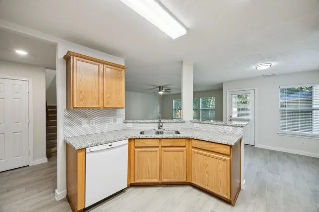 a kitchen with granite countertop white cabinets and white appliances