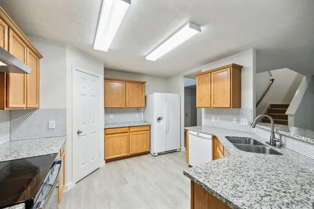 a kitchen with a stove a sink and a refrigerator