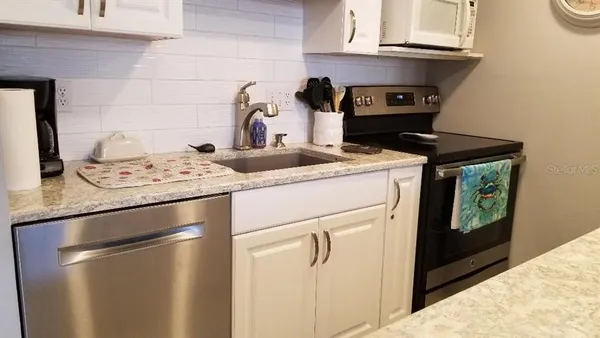 a kitchen with a stove and a white cabinets
