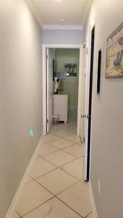 a view of a hallway with bathroom and mirror