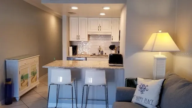 a kitchen with kitchen island granite countertop a sink a counter top space stainless steel appliances and cabinets