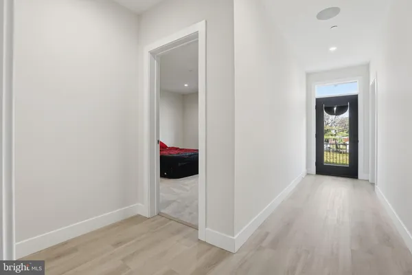 a view of an empty room with wooden floor and stairs