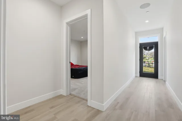 a view of an empty room with wooden floor and stairs