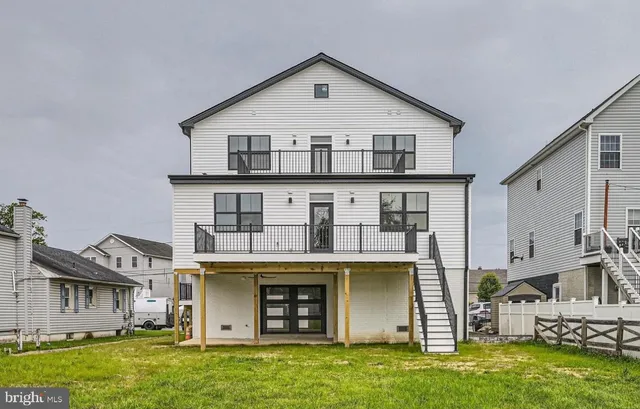 a view of a white building among the street with houses