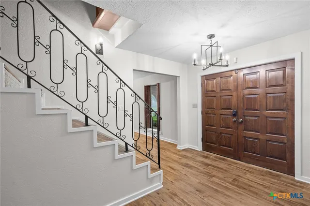 a view of entryway and hall with wooden floor