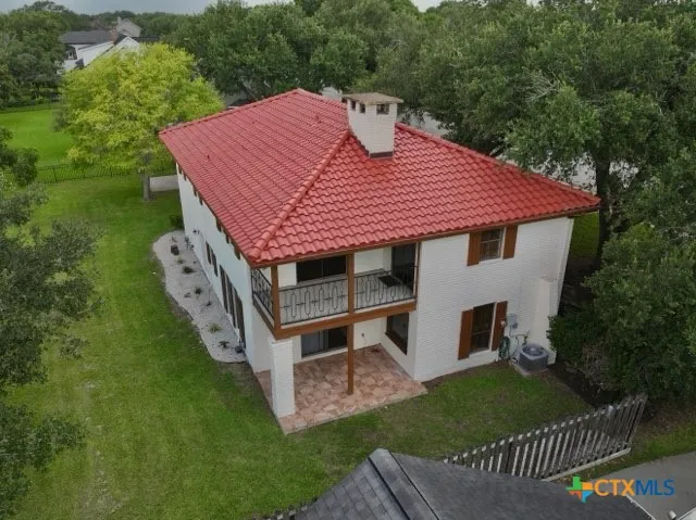 a aerial view of a house with a yard balcony and furniture