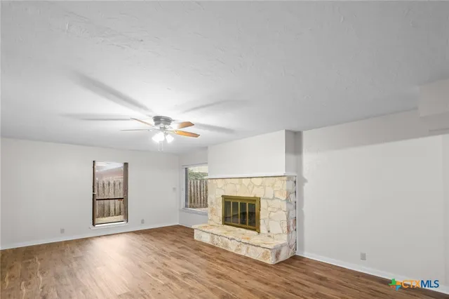 a view of a livingroom with wooden floor and a fireplace