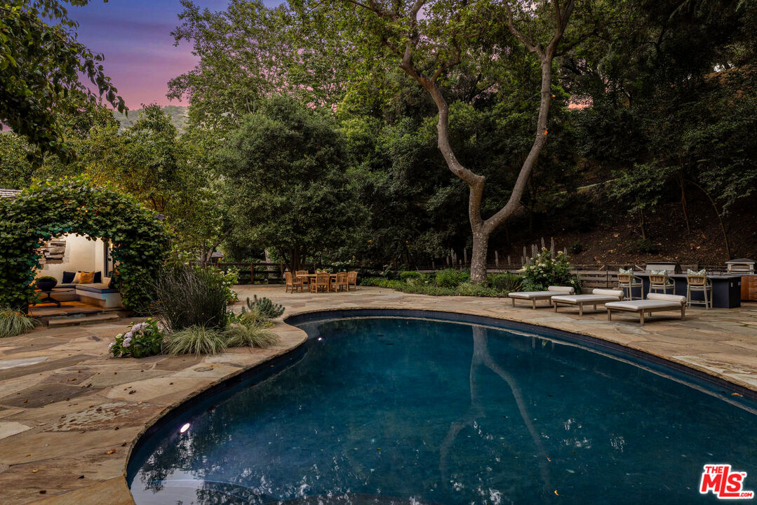 3099 Mandeville Canyon Road Los Angeles, CA 90049 - Photo 12 of 50 a view of swimming pool from a outdoor seating