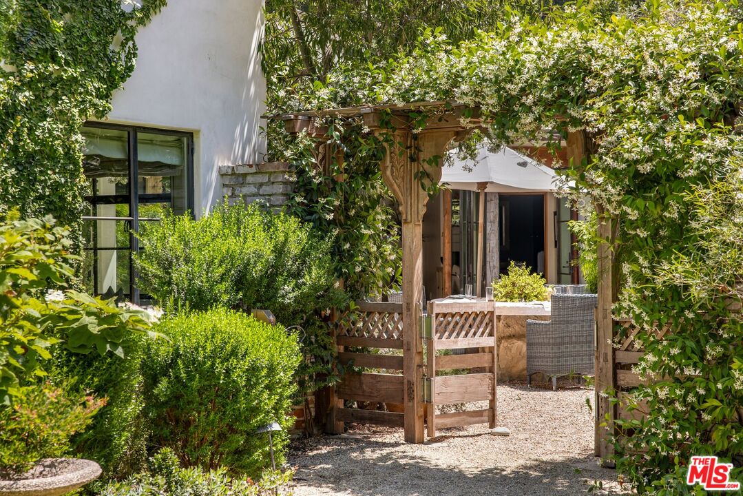 3099 Mandeville Canyon Road Los Angeles, CA 90049 - Photo 16 of 50 a front view of a house with a garden