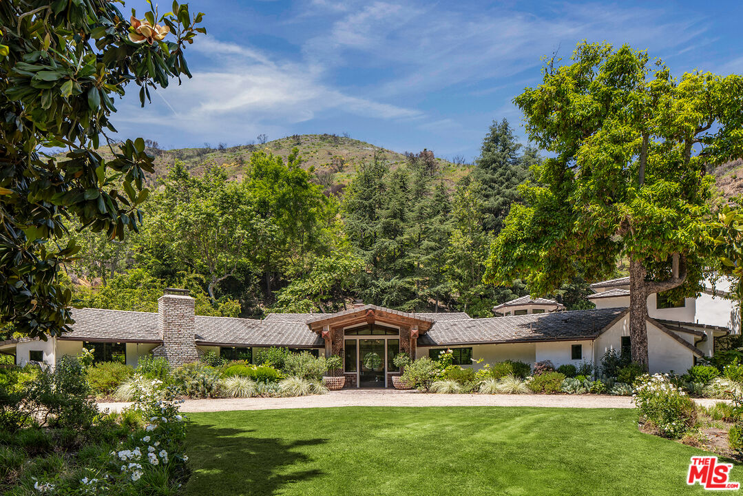 3099 Mandeville Canyon Road Los Angeles, CA 90049 - Photo 2 of 50 a front view of a house with garden