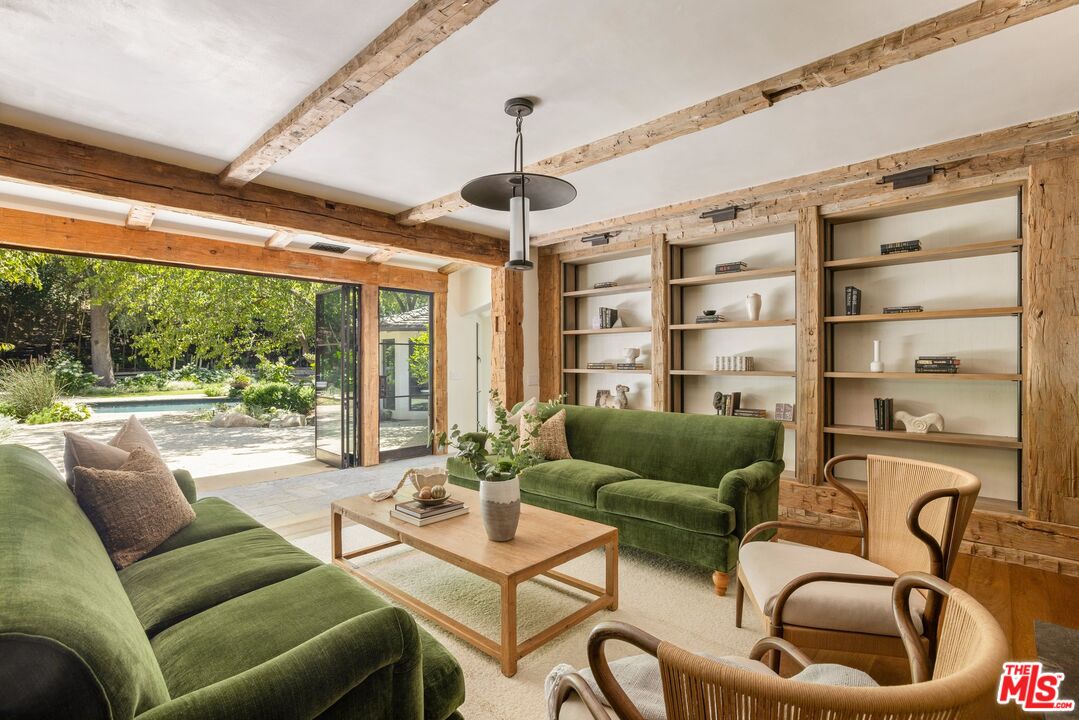 3099 Mandeville Canyon Road Los Angeles, CA 90049 - Photo 23 of 50 a living room with furniture a ceiling fan and a floor to ceiling window