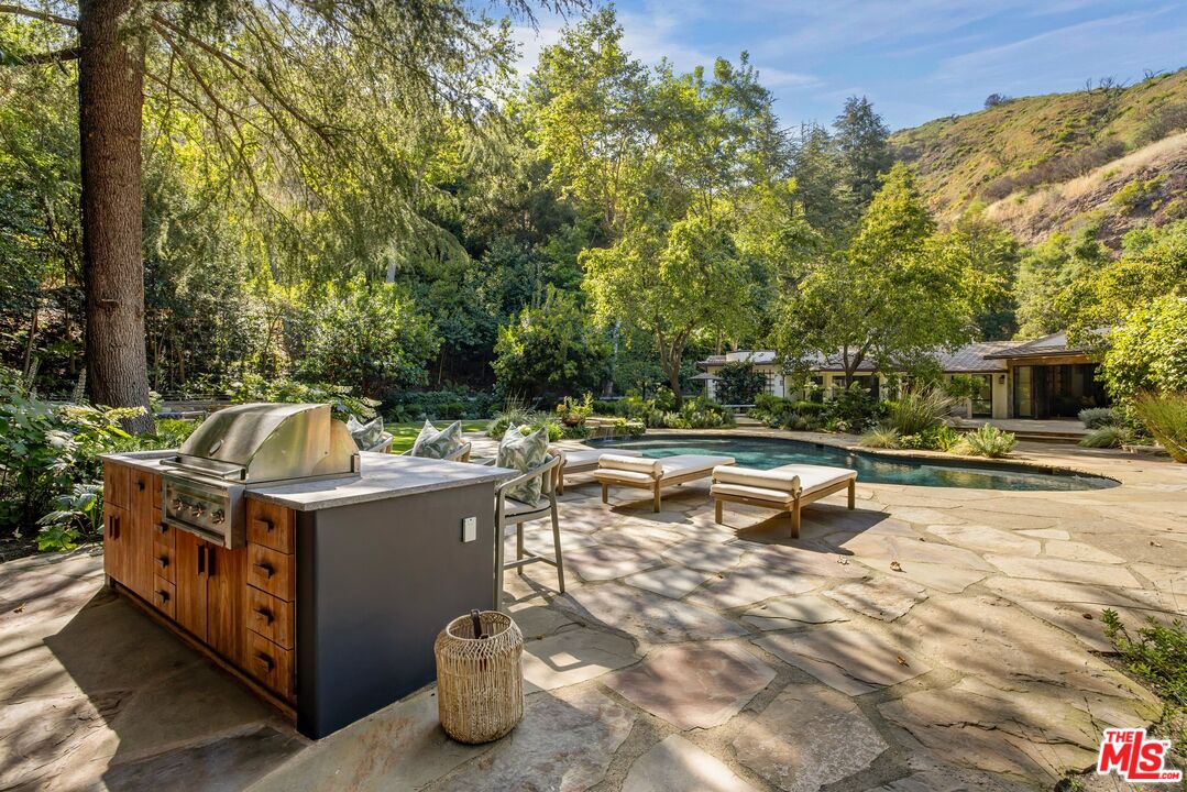 3099 Mandeville Canyon Road Los Angeles, CA 90049 - Photo 28 of 50 a view of a chairs and table in the patio