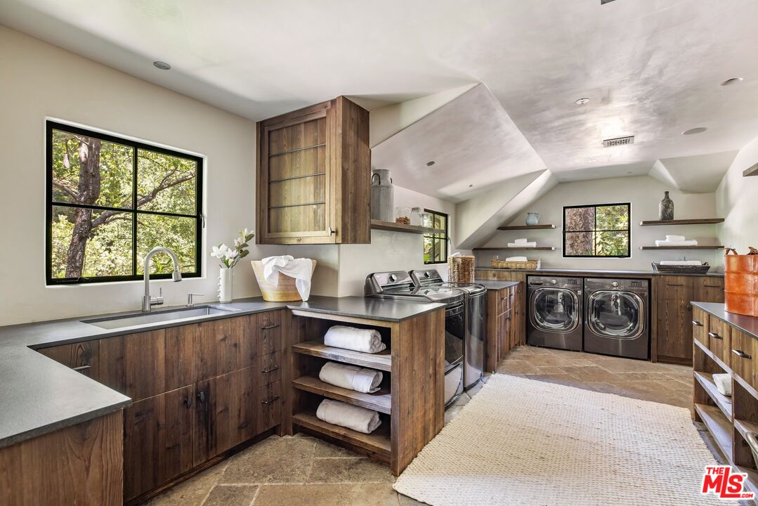 3099 Mandeville Canyon Road Los Angeles, CA 90049 - Photo 36 of 50 a kitchen with stainless steel appliances granite countertop a stove a sink and a refrigerator