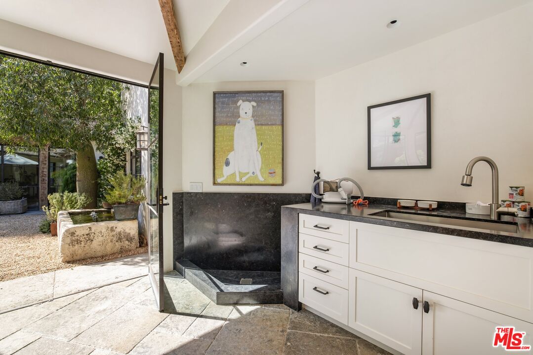 3099 Mandeville Canyon Road Los Angeles, CA 90049 - Photo 37 of 50 a kitchen with granite countertop a sink and a stove next to a window