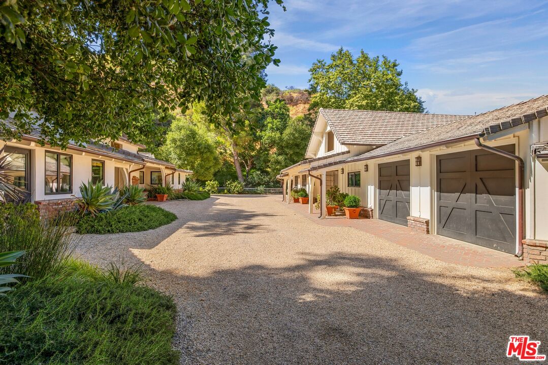 3099 Mandeville Canyon Road Los Angeles, CA 90049 - Photo 38 of 50 a front view of a house with a garden