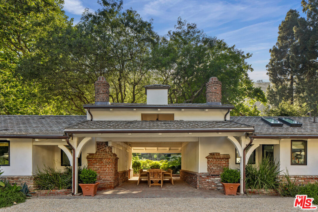 3099 Mandeville Canyon Road Los Angeles, CA 90049 - Photo 39 of 50 front view of a house with table and chairs