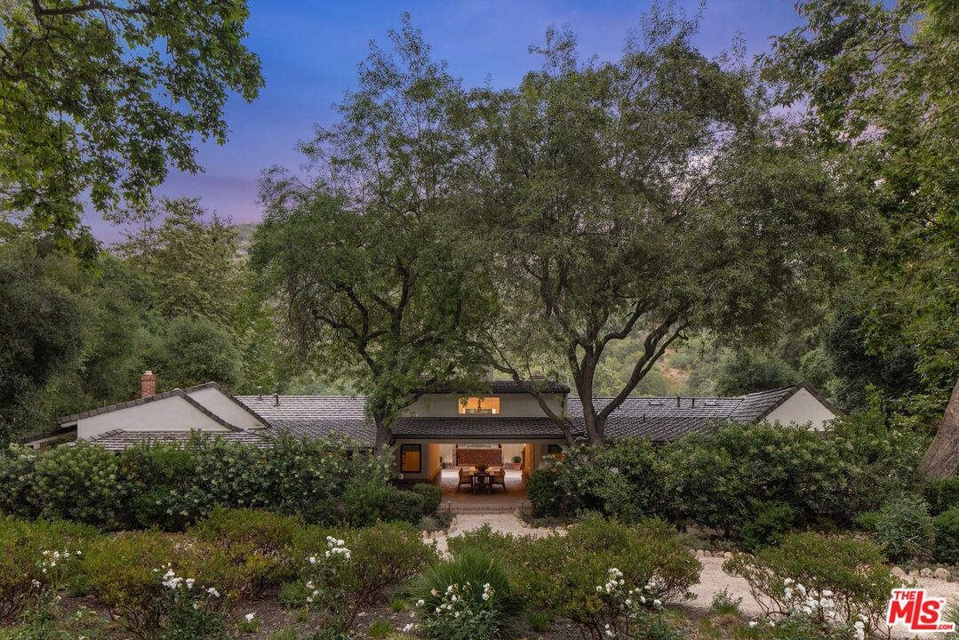 3099 Mandeville Canyon Road Los Angeles, CA 90049 - Photo 4 of 50 a view of a house with a yard