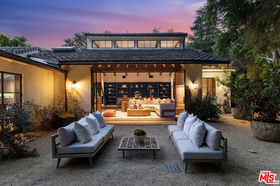 3099 Mandeville Canyon Road Los Angeles, CA 90049 - Photo 6 of 50 a view of a patio with couches table and chairs and potted plants