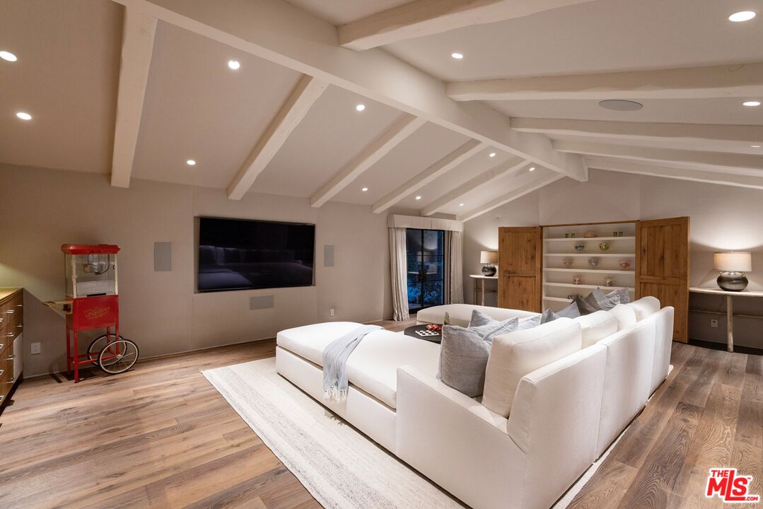 3099 Mandeville Canyon Road Los Angeles, CA 90049 - Photo 10 of 50 a living room with furniture and a flat screen tv