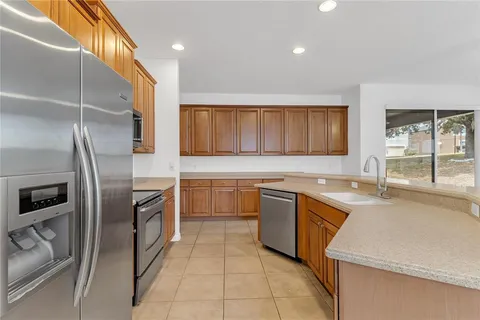 a kitchen with stainless steel appliances granite countertop a refrigerator a stove a sink and a microwave