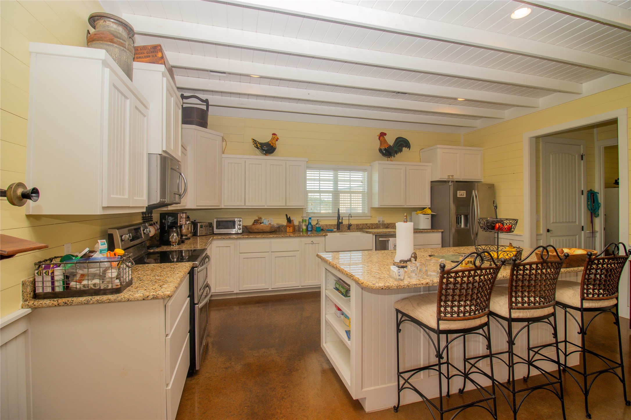4237 County Road 330 Burnet, TX 78611 - Photo 11 of 40 Kitchen with open shelves, stainless steel appliances, a breakfast bar, a center island, and white cabinets