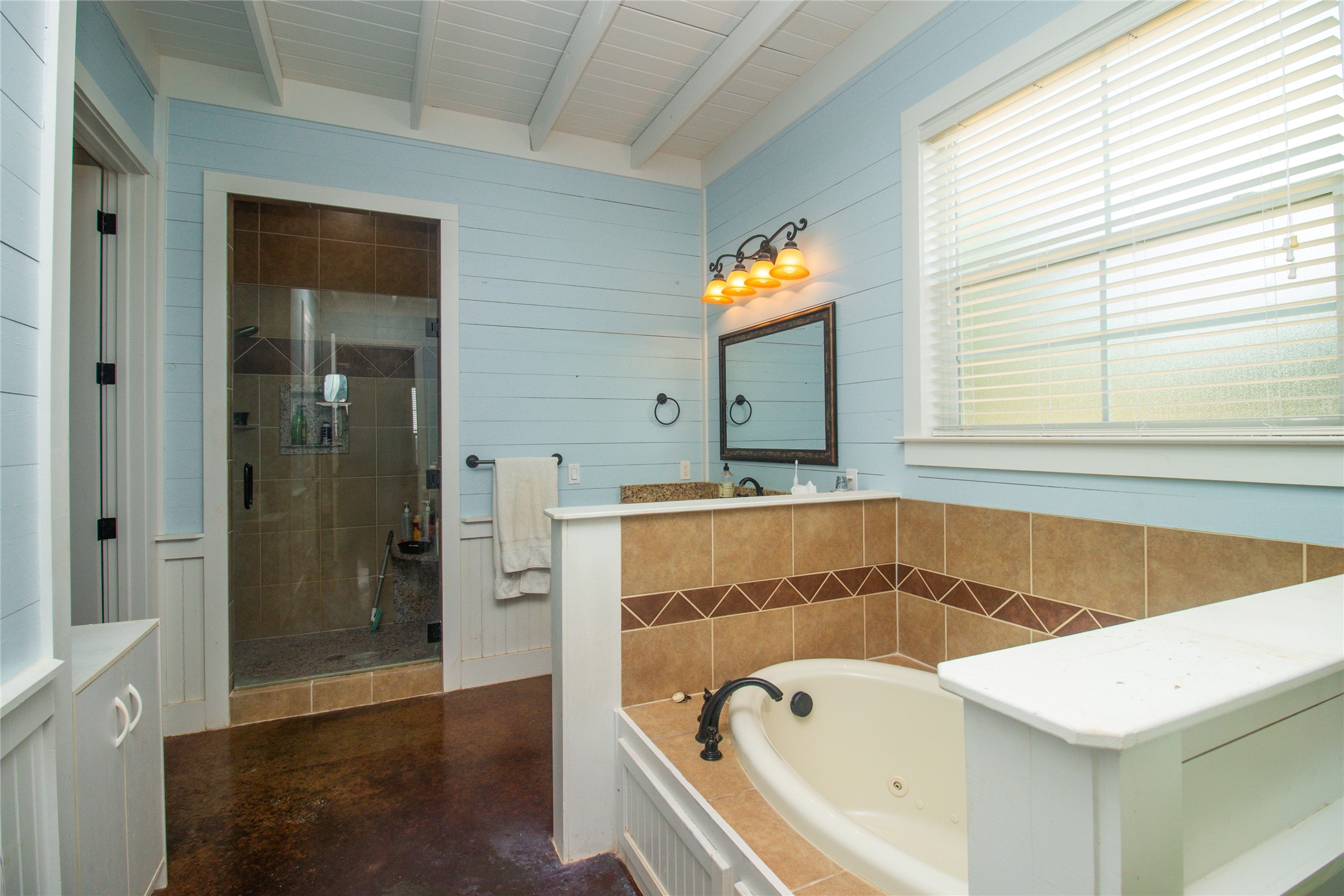 4237 County Road 330 Burnet, TX 78611 - Photo 30 of 40 Full bath with a jetted tub, a shower stall, beam ceiling, wood walls, and finished concrete floors