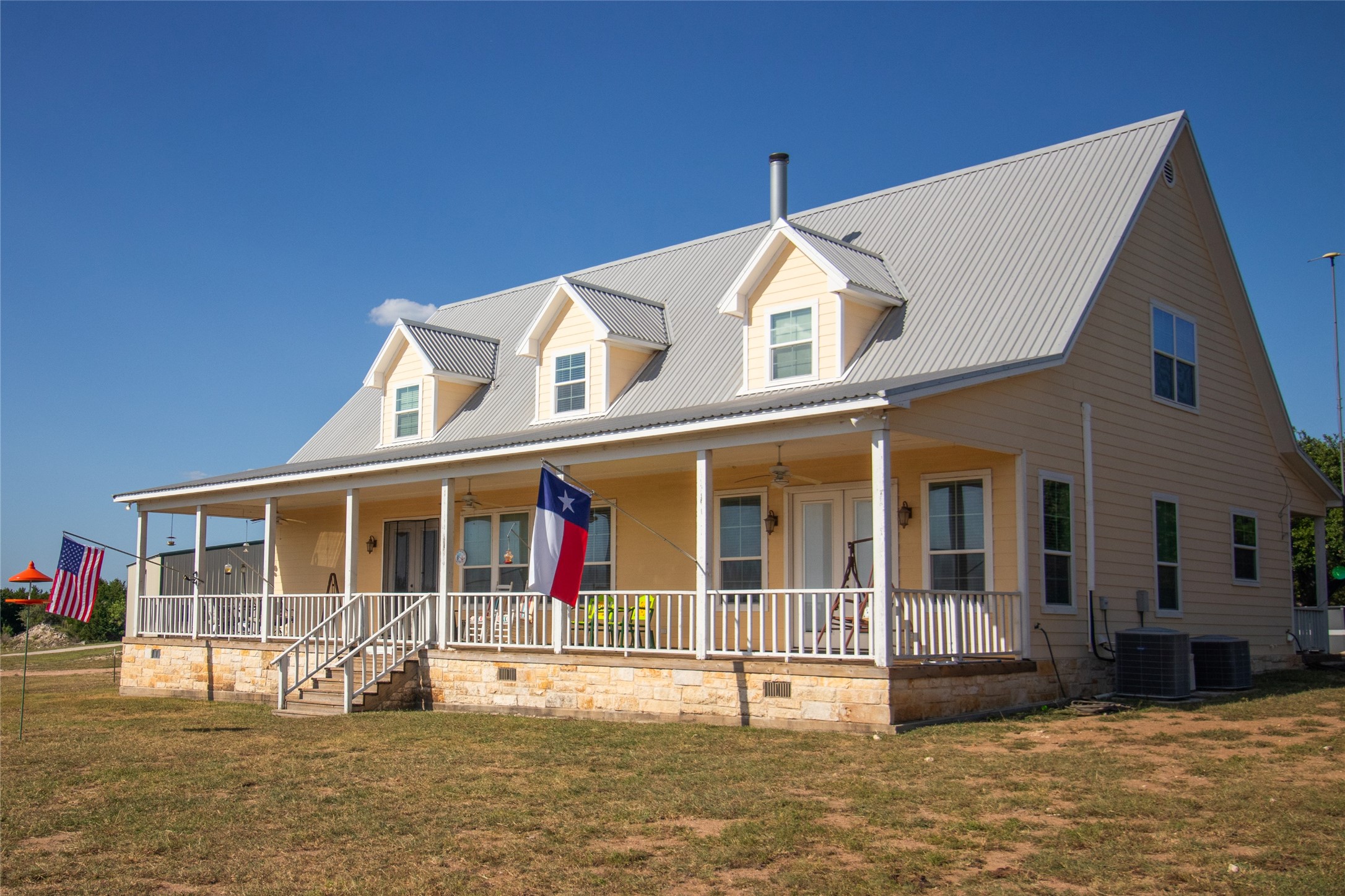 4237 County Road 330 Burnet, TX 78611 - Photo 33 of 40 a view of a white house with large windows and a small yard