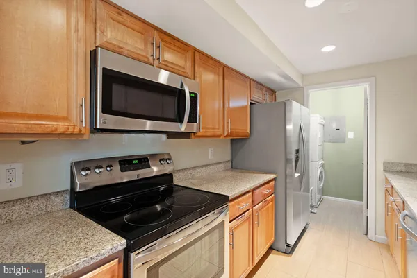 a kitchen with stainless steel appliances a stove a microwave a sink and cabinets