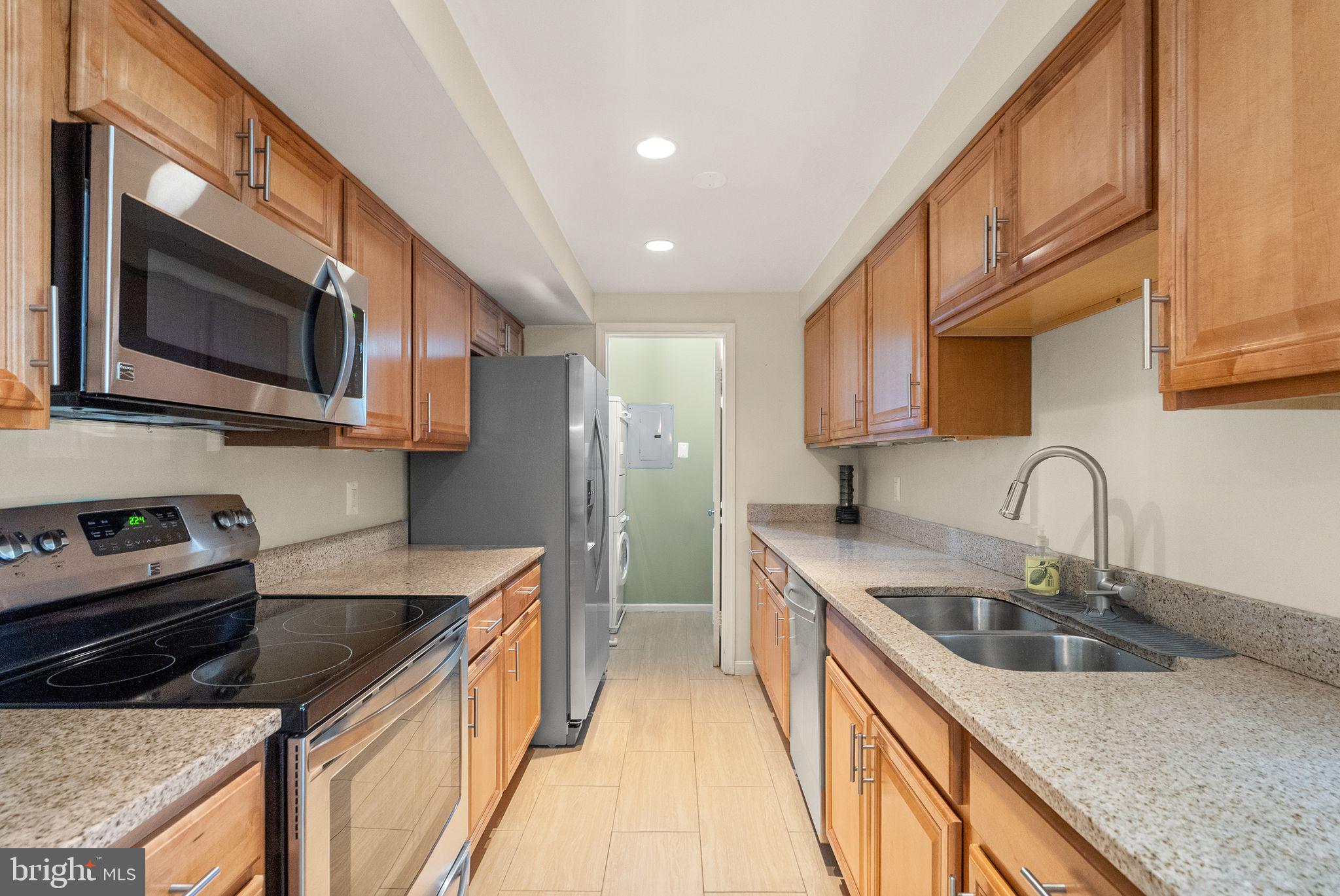 6905 Keyser Way Alexandria, VA 22310 - Photo 17 of 50 a kitchen with stainless steel appliances granite countertop a sink a stove top oven a refrigerator cabinets and a kitchen island