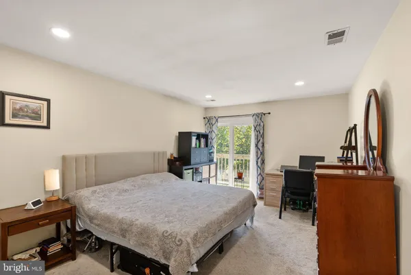 a bedroom with a bed a table and a flat screen tv