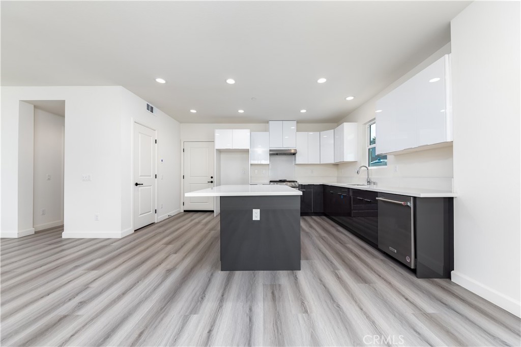 1371 Point Loma Place Walnut, CA 91789 - Photo 15 of 37 a large kitchen with stainless steel appliances refrigerator a sink dishwasher a stove top oven a refrigerator with white cabinets and wooden floor